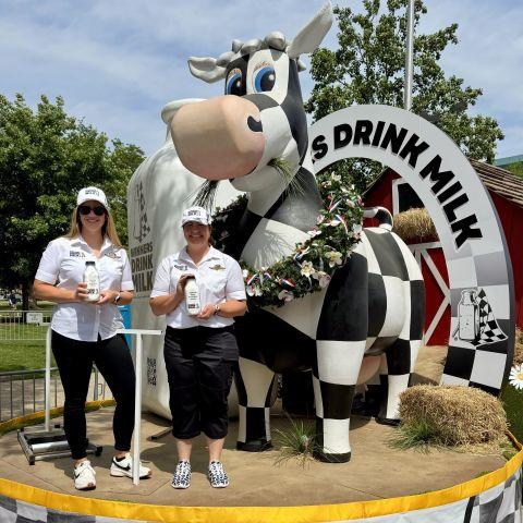 Abbie Herr with pint of milk in front of large cow