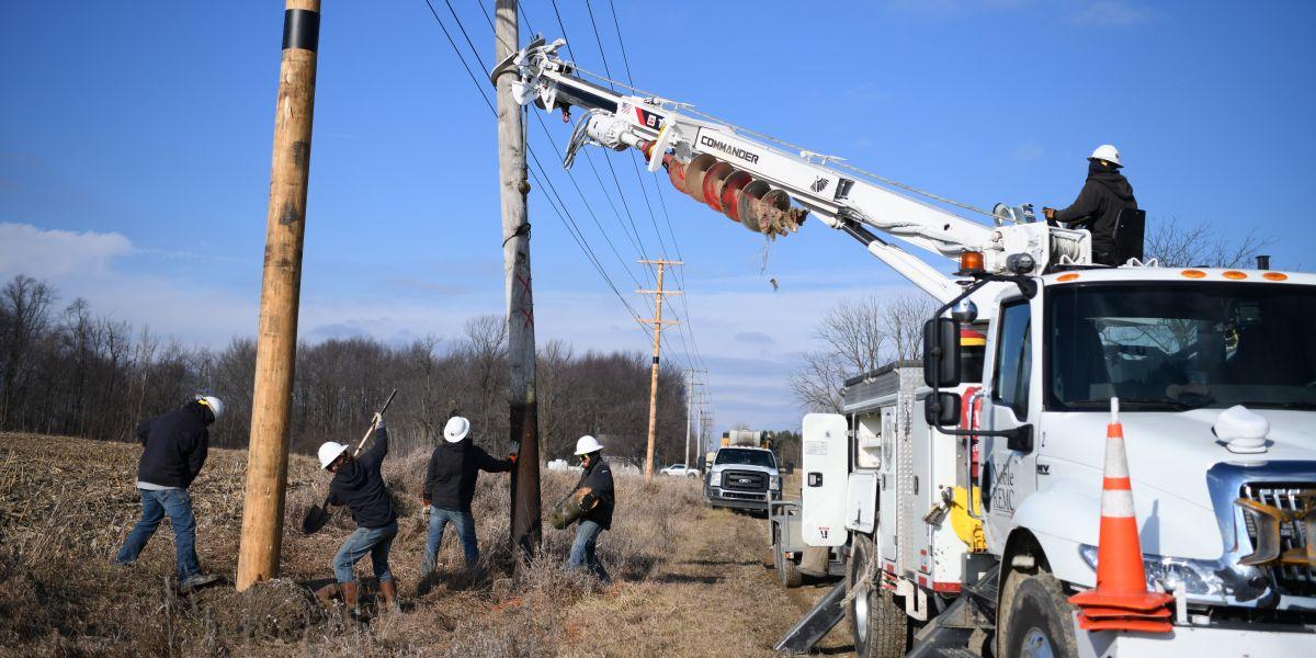 Lineworkers installing new power pole